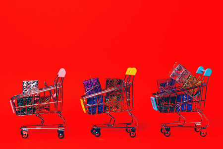 Small decorative trolleys with present boxes on bright colorful 