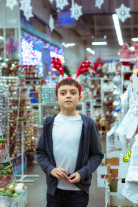 一个十岁的男孩手里拿着一个圣诞玩具，圣诞节的心情，一个孩子在购物中心微笑。寒假概念。