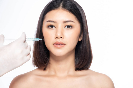 Asain young woman gets injection of botox in her lips. Woman in 