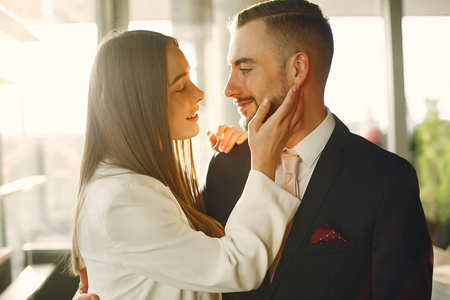 Elegant couple in a suits spend time in a cafe