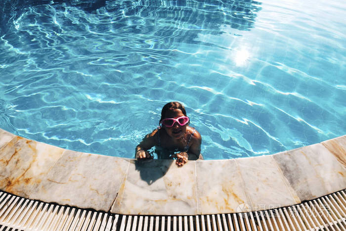 美丽的小女孩在游泳池放松