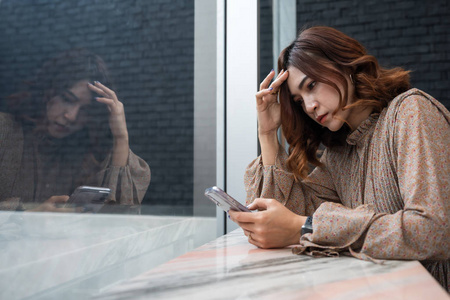 沮丧的女人看着她的智能手机头痛