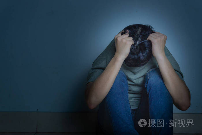 一个悲伤的男人独自坐在黑暗的房间里哭泣德普尔
