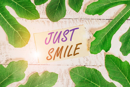 写便条，露出微笑。商业照片展示假设一个面部表情表明愉快或娱乐树叶围绕在一张经典的木桌上的信纸周围。