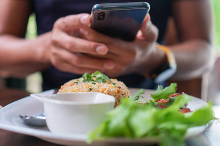 在餐厅里用手机在盘子里拍照的男人在社交网络中的美好交流。