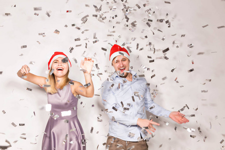 新年圣诞节和派对理念欢快的年轻人在白色背景上洒下五彩纸屑。