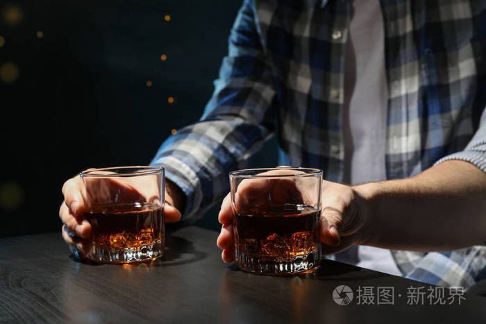 男人们在酒吧里喝威士忌特写模糊的灯光男人喝酒