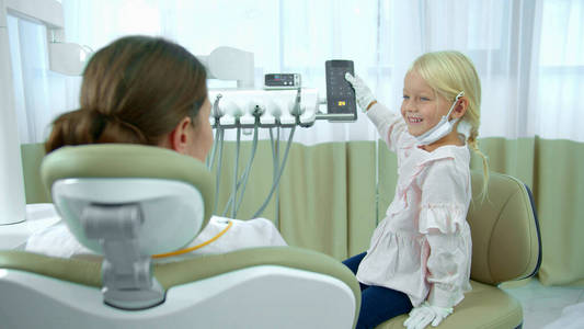 那个女孩调节着牙医坐的椅子。