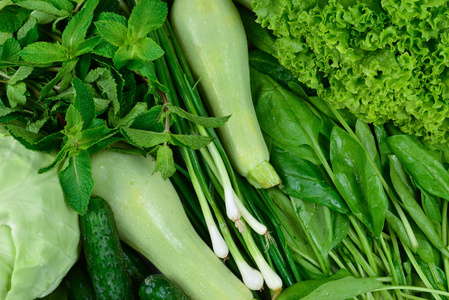 Fresh green vegetables and herbs as a background.  