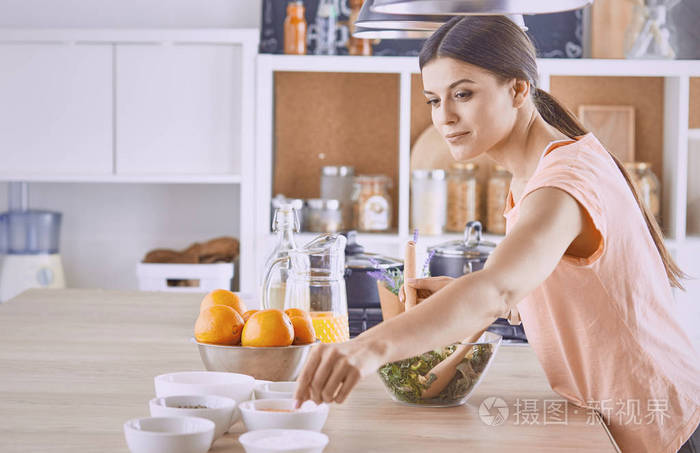 快乐的年轻厨师女孩正在用蔬菜做食物