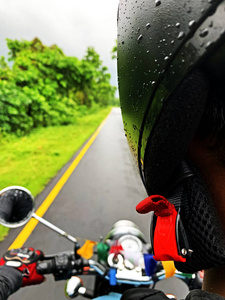 一个骑摩托车的年轻人在雨中旅行