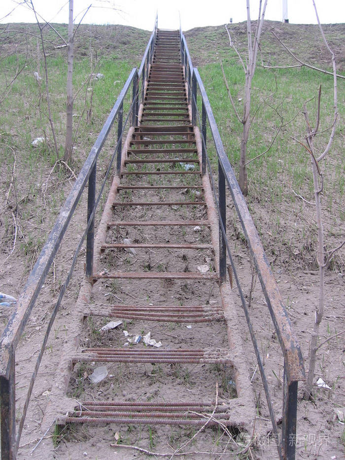 斜坡上有一个旧的肮脏的金属楼梯通向那里