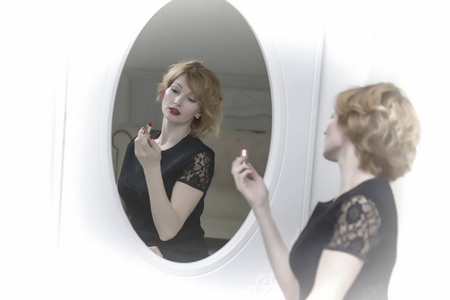 年轻女子在镜子旁边用睫毛膏。美丽和关怀。研究