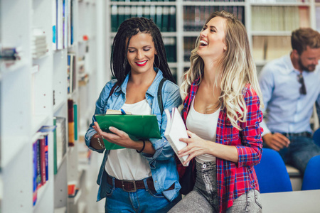 学生们正在图书馆学习。年轻人在浪费时间