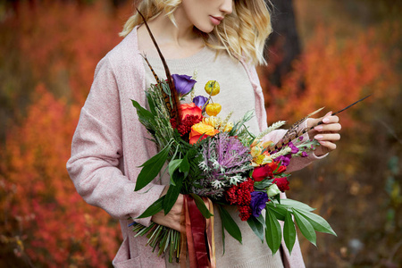 Girl walking in the autumn forest. A large beautiful bouquet of 