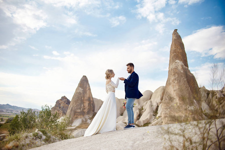 Couple in love hugs and kisses in fabulous mountains in nature. 