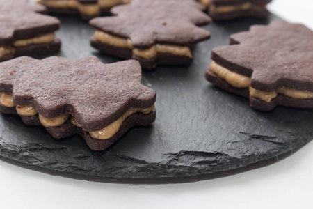 在黑色托盘上放一个圣诞树形状的自制巧克力饼干