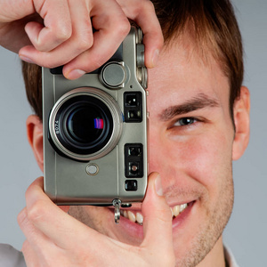 年轻摄影师用胶卷相机拍照的肖像