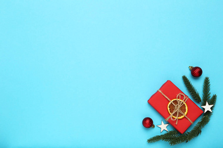 平铺圣诞作文。蓝色背景上有圣诞饰品和冷杉树枝的礼品盒