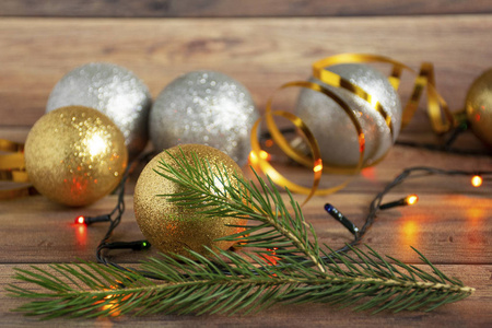 金色和银色圣诞球和彩色花环在木制圣诞背景上。复制空间。