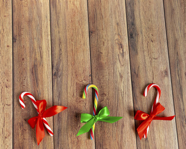 圣诞饰品，冷杉树枝，礼物，圣诞树球，糖果棒，棕色木桌上的文字纸。圣诞木背景。新年，圣诞节，寒假，复制空间。