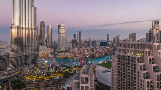 日落后的迪拜市中心全景天际线景观，有购物中心喷泉和摩天大楼，白天到晚上都可以欣赏到