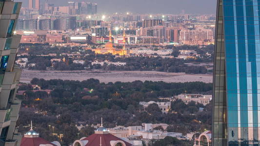 鸟瞰Deira和Dubai creek附近的典型老建筑和现代建筑，日夜延迟。