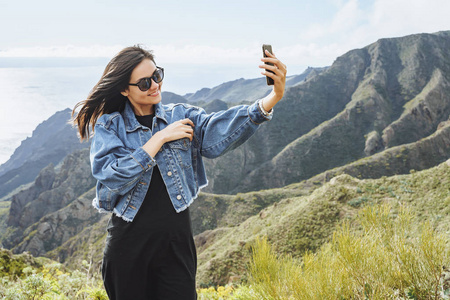 手机海拔快乐女游客山顶智能手机自拍照片
