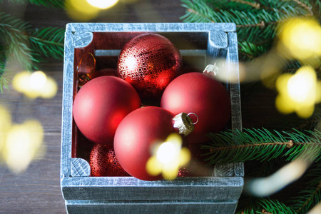 红色圣诞玩具，云杉树枝和松果创造了一个新的新年气氛。圣诞快乐，新年快乐。变模糊。