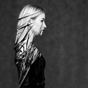 黑白双曝光肖像,美丽的模特女孩,梳着梳头,浓妆艳抹,灰色背景.照片