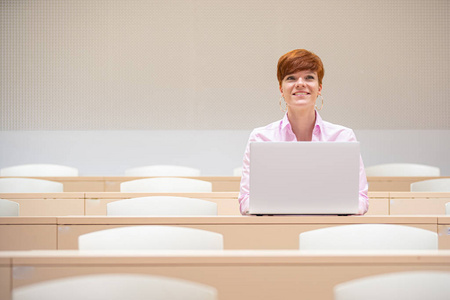 一位年轻漂亮的女士在大学讲课时用笔记本电脑工作