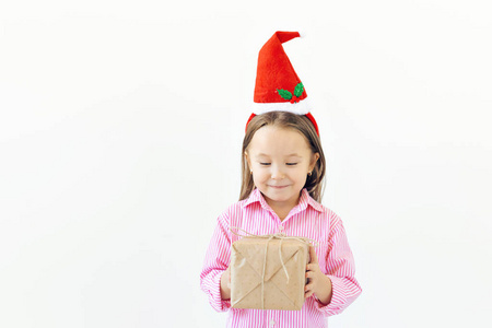 圣诞概念快乐的小女孩微笑着，白色背景上有复制空间的礼品盒