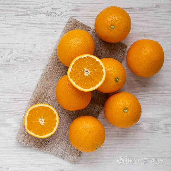 新鲜成熟的有机橘子放在一张白色的木桌上，俯视。佛罗里达州