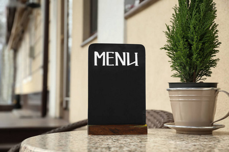 Empty menu board on table in outdoor cafe