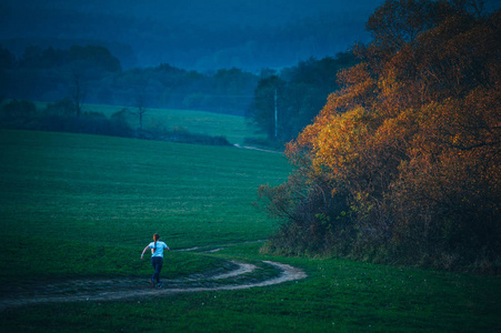 女人在晚秋自然中奔跑。最后的落日余晖