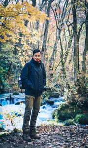 Asian man enjoying autumn forest 