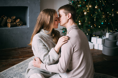 一对情侣在家里的圣诞树旁接吻，新年