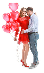 幸福的年轻夫妇，白色背景上有心形气球。情人节庆祝