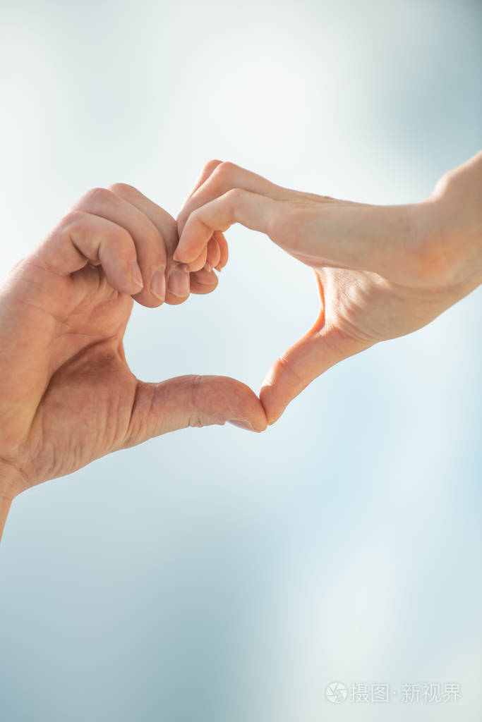 爱心脏标志图标情人节概念男人和女人的手一起对着天空美丽的爱情象征