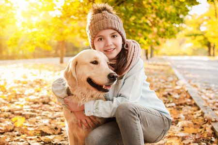 秋天公园里带着可爱狗的小女孩
