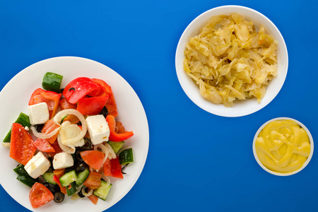  Greek salad on a colored background. Greek salad on a white pla