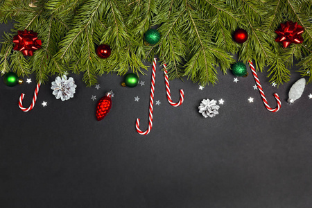 Christmas border from fir branches, decorations and candy canes 