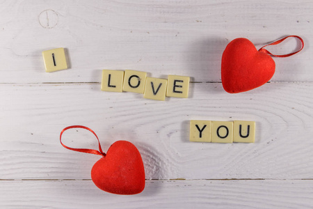 Red hearts and I Love You text on white wooden background