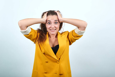 美女很黄一位身穿黄夹克的年轻女子双手捂着头,看上去很震惊照片