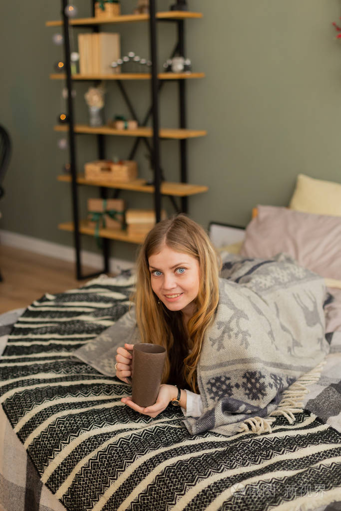 美女在花格布下的床上喝茶现代时尚的房间设计