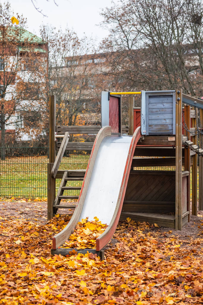 emptyoldchildrenslidewithmapleleavesatautumnday