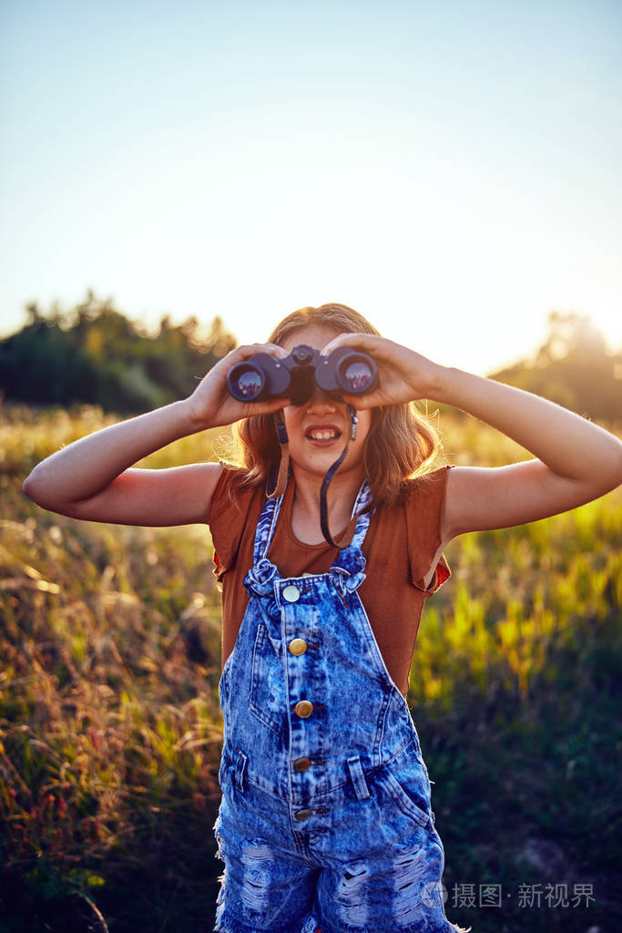 小女孩在大自然中使用双筒望远镜