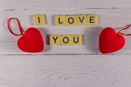 Red hearts and I Love You text on white wooden background