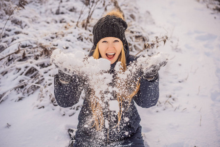 女人在冬天玩得开心，扔雪