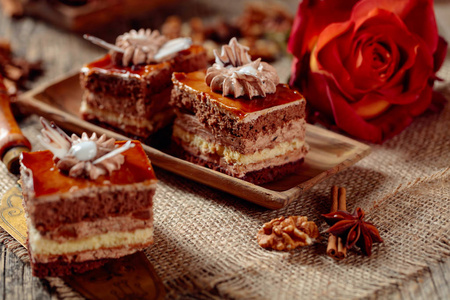 Layered cakes with spices and nuts on a old wooden table. 